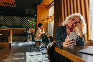 Woman at coffee shop using mobile phone