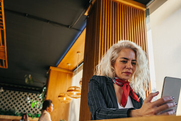 Business woman using mobile phone at the cafe