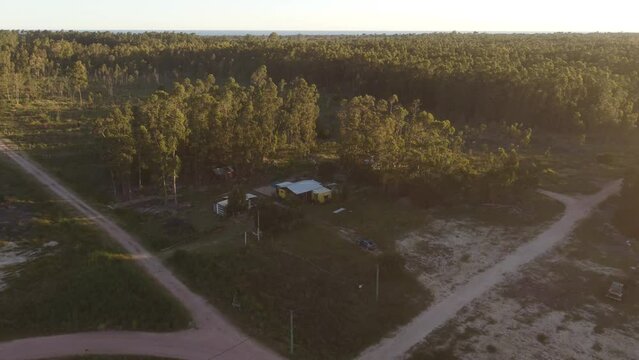 A drone pushes towards a wood cabin in Punta del diablo.