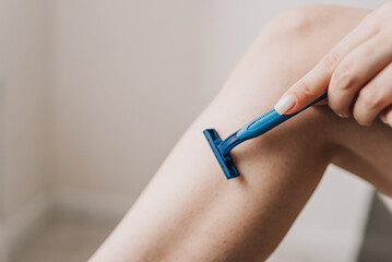 shaving legs with a blue razor