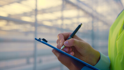 Closeup factory supervisor checking producing in greenhouse analyzing data