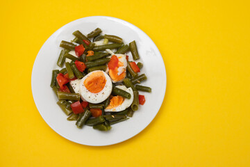 healthy salad green beans, pepper and boiled eggs on plate