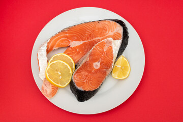 raw fresh salmon on ceramic plate on red