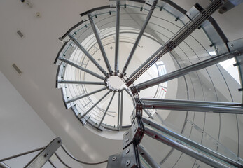 Spiral staircase made of glass and metal in luxury house.