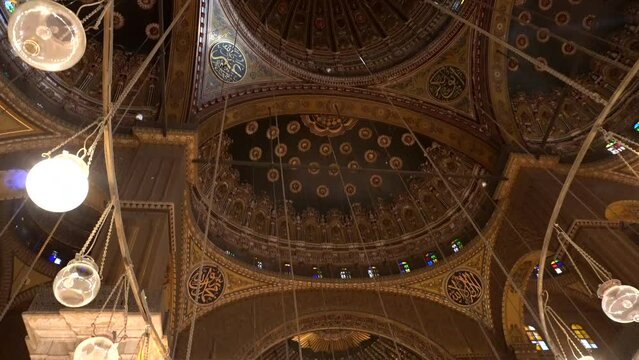 Mosque of Muhammad Ali interior illuminated chandelier ceiling with painting of Arab muslim in arch