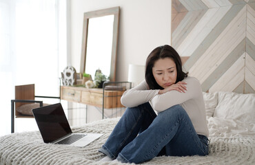 Obraz premium Young asian woman read bad news on laptop look desperate, feels stressed, important data loss, notice form bank about debt, upset user customer using laptop feel frustrated mad about computer problem