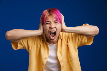 Asian boy with pink hair screaming while holding his head