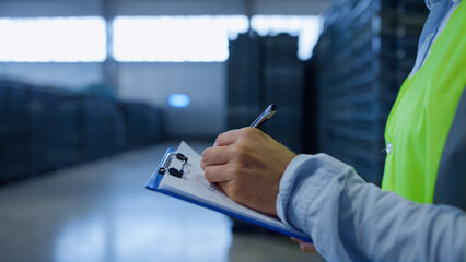 Warehouse worker making notes collecting information analysing shipment process