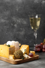 Shropshire, langre, asiago, gorgonzola, shanklish cheese with glass of white wine on dark...