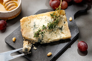 Cheese platter with gorgonzola cheese, rosemary, honey and fork.