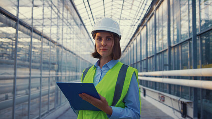 Portrait woman engineer noting information analysing factory productivity 
