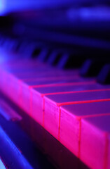 close up of piano keys, piano keyboard in neon pink light