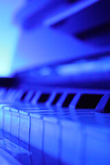 close up of piano keys, piano keyboard in blue light