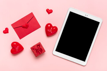 tablet for chooses gifts, makes purchase, envelope, box, two red hearts on pink table Top view Flat lay Holiday shopping list, Happy Valentine's day, party, online shop concept Mock up