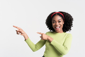 Young black woman smiling and pointing fingers aside