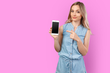 Naklejka premium Portrait of a smiling woman showing blank smartphone screen isolated on a color background