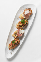 Pinchos tapas with jamon serrano and bruschetta on white background