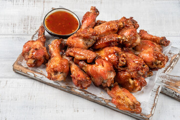 Chicken wings with sriracha sauce on wooden table