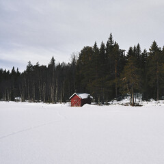 red boathouse by Vesle Vålsjøen Lake up in the Totenåsen Hills, Norway, in winter