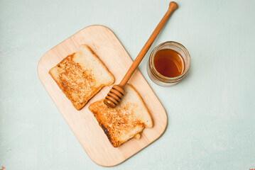 Toast with honey sliced on a wooden board.