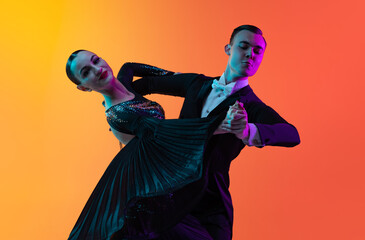 Close-up emotive dancing couple, beautiful man and woman dancing waltz isolated over gradient...