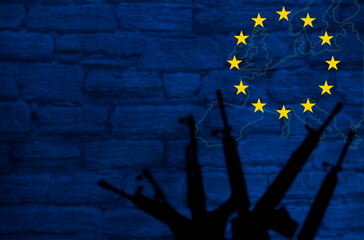 Weapons silhouettes on the background of the EU flag. Stone wall with a map of the European Union....