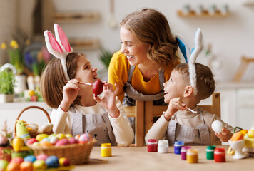 Happy easter! family mother and cheerful children with ears are getting ready for holiday
