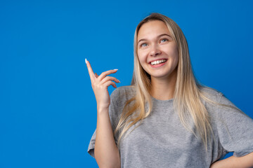 Fototapeta premium Portrait of pretty teen girl thinking and creating solution against blue background