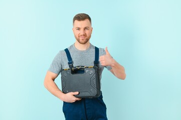 Craftsmen or electrician man over isolated blue background giving a thumbs up gesture