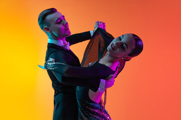 Close-up emotive dancing couple, beautiful man and woman dancing waltz isolated over gradient...
