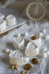 Various types of cheese with white mold on packaging paper.