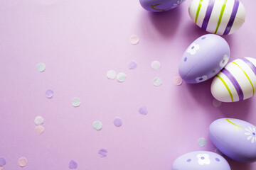 painted easter purple eggs with ornament and decor on pastel background. copy space