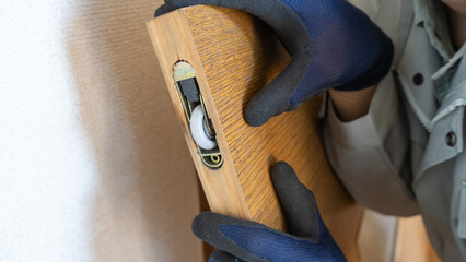 扉(スライドドア)の戸車を修理・点検する作業員