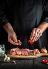 Professional chef prepares raw veal meat. Before baking, the cook puts the viburnum on the beef. National dish is being prepared in the kitchen