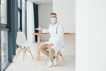 Male doctor near reception desk in clinic