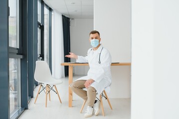 Male doctor near reception desk in clinic