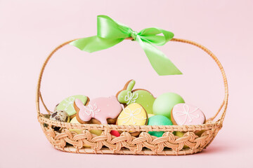 Colorful easter cookies in basket with Multi colors Easter eggs on colored background . Pastel color Easter eggs. holiday concept with copy space