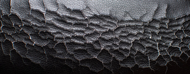 Texture of old cracked black leather close-up