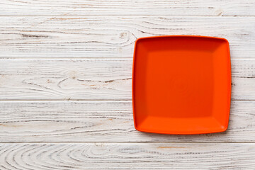 Top view of empty square plate on wooden background. Empty space for your design