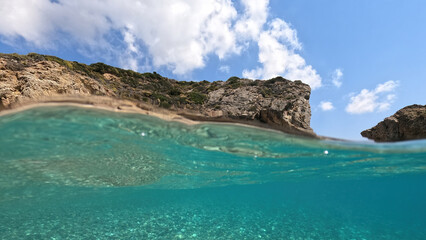 Fototapeta na wymiar Underwater split photo of natural exotic island rocky bay with turquoise crystal clear sea and small caves