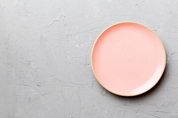 Top view of empty pink plate on cement background. Empty space for your design