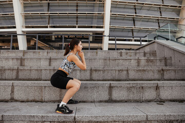  Teenage girl doing sports warm up before workout outdoors of the city background