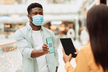 Worker Scanning Visitor's Qr Code On Entrance To Public Place