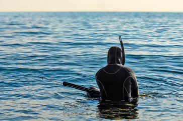 Scuba diver with spear gun in water - spearfishing