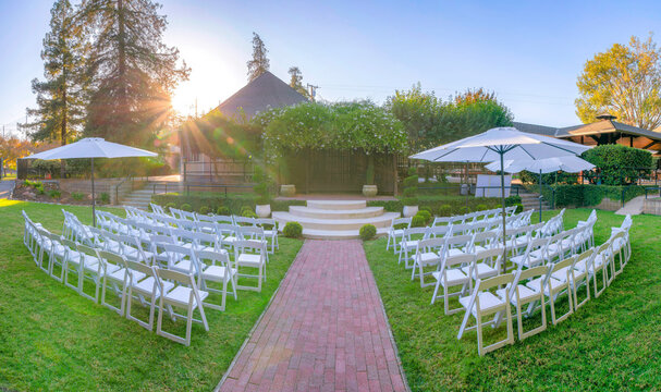 Garden wedding venue with white chairs and umbrellas in California