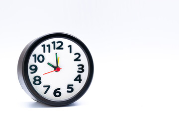 Black alarm clock isolated on white background. The clock set at 10 o'clock.