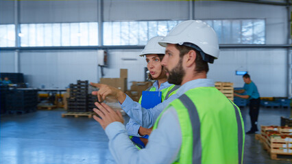 Factory warehouse supervisors discussion checking tablet information talking
