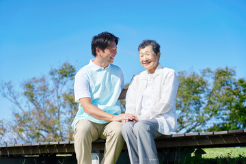介護士と高齢者　屋外