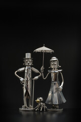 Fototapeta na wymiar 犬の散歩をする相合傘の紳士と淑女の模型・メタルフィギア