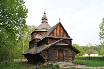 Fototapeta na wymiar An old wooden church in Ukraine. Rural landscape with a church. Wooden Ukrainian church. The green landscape of the countryside. Kiev. Ukraine.